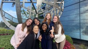 Students stand together around a metal globe 