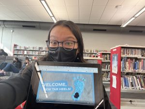 A photo of a young person showing a computer screen.