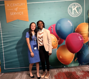 Chikanma and a fellow Key Club leader pose smiling in front of a banner that says "A Century of Service"