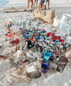 Assorted litter, a heap of bottles, cans, cups, and buckets.