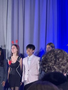 a photo of young people standing on stage in formal wear