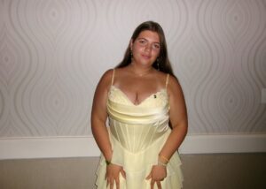 A young person wearing a pale yellow summer dress poses for a photo